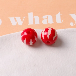 Macro shot of 16mm red pumpkin resin beads with white wavy pattern for DIY jewelry