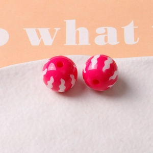 Macro shot of 16mm rose pink resin beads with white wavy patterns for DIY jewelry