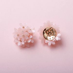 Macro view of handmade pink five-petal flower charms with golden beads and metal base
