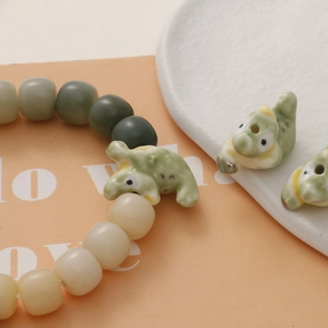 Detailed view of DIY ceramic bead bracelet with cute light green crocodile charms