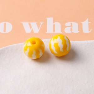 Detail of 16mm yellow pumpkin resin beads with white wave patterns for DIY jewelry making