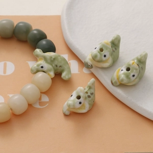 Detailed view of handmade green crocodile ceramic beads and gradient beaded bracelet