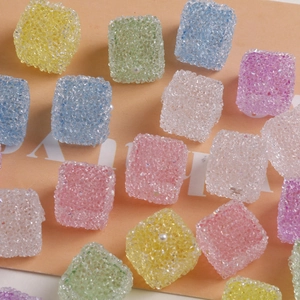 Vue macro de perles cubes en résine 16mm avec texture sucre et perles pour bijoux DIY