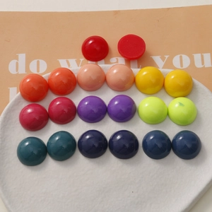 Colorful 18mm resin half-round beads in a ceramic tray for DIY jewelry and crafts