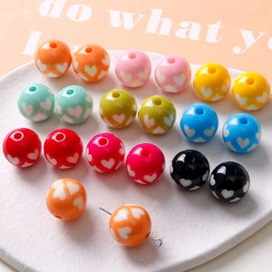 Gros plan de perles en résine 16mm avec motifs de cœur pour la création de bijoux