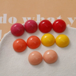 Close-up of 18mm round dome resin cabochons in dark mixed warm colors for DIY crafts