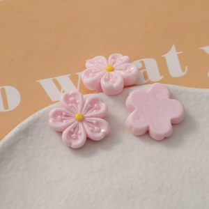 Detail showing pink resin cherry blossom charms with yellow stamens for DIY crafts