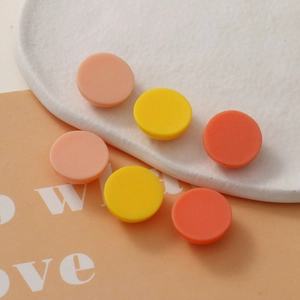 Detail of 18mm round resin flatback charms in warm orange and yellow tones for DIY crafts
