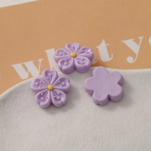 Macro view of light purple resin flower charms with a flat back for DIY crafts