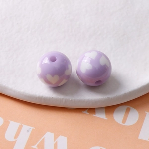 Vue détaillée macro de perles rondes en résine violet clair avec motif de cœur pour DIY