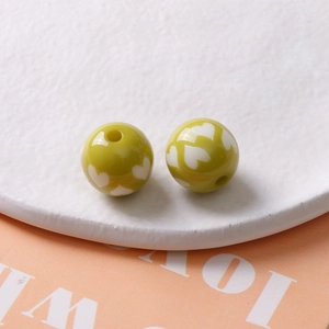 Gros plan de perles en résine verte de 16mm avec motifs de cœur pour bijoux DIY