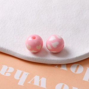 Gros plan de perles en résine rose de 16mm avec motifs de cœur blanc pour bijoux DIY
