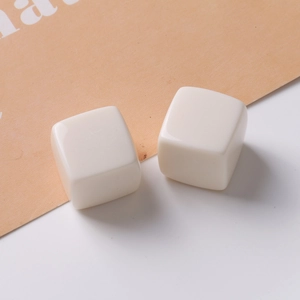 Macro view of two 20mm creamy white resin square cube charms for DIY jewelry and crafts