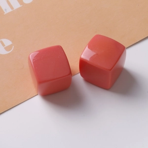 Macro shot of two 20mm glossy coral resin cube charms for DIY jewelry and earrings