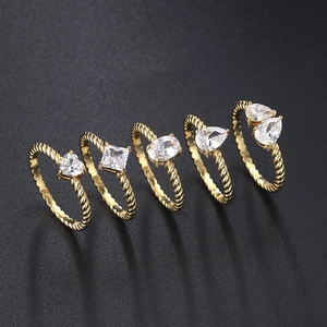 Detail of five-piece gold ring set featuring varied geometric zircons and twisted bands