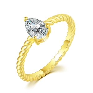 Macro shot of gold teardrop gemstone ring with braided band detail and 3-prong setting