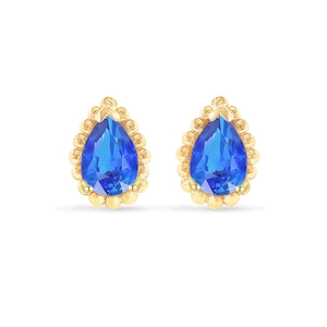 Detalle de pendientes de circonita azul en forma de gota con bordes de cuentas doradas