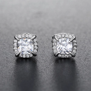 Macro shot of silver hip hop stud earrings with cushion cut zircon and halo setting