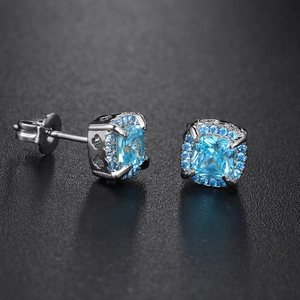 Detailed close-up of square blue zircon stud earrings with micro-pave silver setting