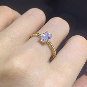 Detail shot of an oval-cut solitaire zircon ring with a golden twisted rope band design