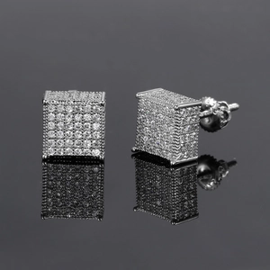 Vue macro des boucles d'oreilles carrées argentées avec zircons sertis pavés et reflets nets
