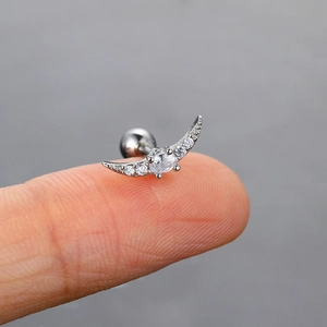 Makro-Detail des Mondsichel-Ohrsteckers mit Zirkonia-Mikropflasterung auf einem Finger