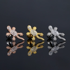 Vista detallada de tres pendientes de lagarto en acabados oro, plata y oro rosa brillante