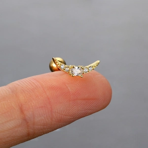 Makroaufnahme von kleinem Mond-Ohrstecker aus Gold mit Zirkonia auf Fingerspitze