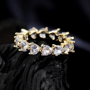 Macro view of gold eternity ring featuring heart-shaped cubic zirconia in a prong setting