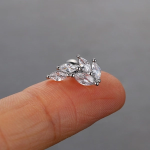 Makroaufnahme von blattförmigem Edelstahl-Ohrstecker mit Marquise-Zirkonia auf der Fingerspitze