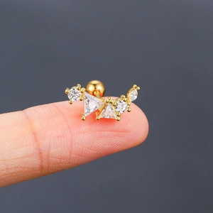 Makroaufnahme von Gold-Ohrknorpel-Piercing mit Zirkonia-Steinen, gehalten von einem Finger