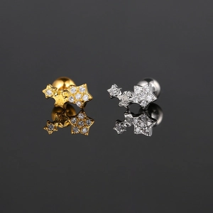 Vista macro de pendientes de circonita con tres estrellas y cierre de rosca en oro y plata