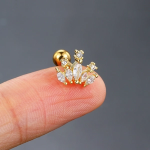Nahaufnahme eines goldenen Kronen-Piercings mit weißen Zirkonia auf einem Finger