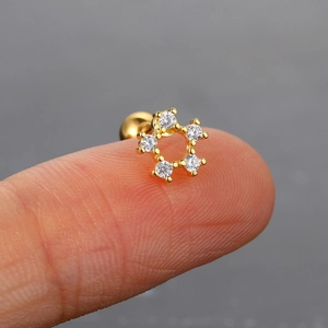 Vista macro de un pequeño piercing de estrella dorada con cinco circonitas claras