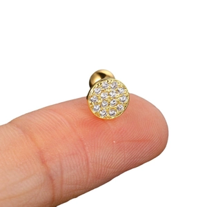 Minimalistische goldene runde Ohrstecker mit Zirkonia, auf der Fingerspitze gezeigt