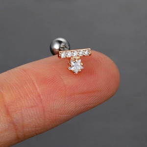 Primer plano detallado del piercing de oreja de oro rosa con colgante estrella y circonitas
