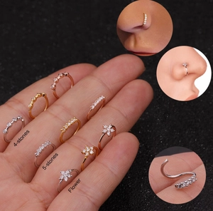 Detail view of micro-paved zircon nose rings in silver, gold and rose gold flower designs