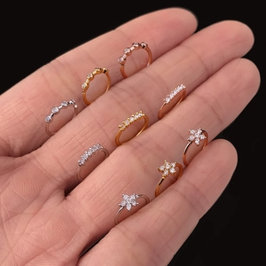 Detail of micro-pave zircon nose rings and ear piercings in gold, silver and rose gold