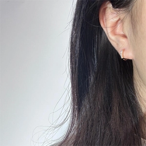 Close-up of minimalist 18K gold plated C-shaped nose ring with micro-paved cubic zirconia