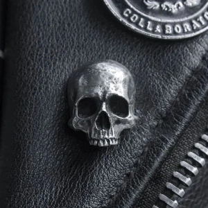 Macro detail of retro skull pin with vintage silver finish on black leather jacket