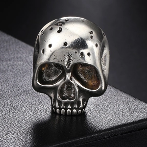 Macro detail of gothic skull pin with vintage silver finish and punk textured metal work