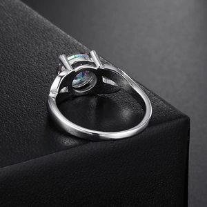 Macro d'une bague en argent avec pierre de topaze mystique dans une monture à quatre griffes