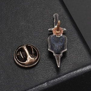 Macro view of vintage silver dagger pin with metal butterfly clasp on black leather