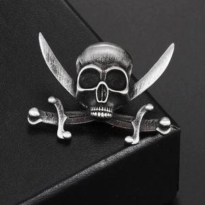 Close-up of vintage silver skull and crossbones brooch with retro metallic texture