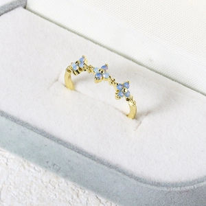 Elegant gold-plated ring with three blue zircon flowers displayed in a jewelry box