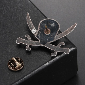 Macro view of retro skull and crossbones brooch with back pin and butterfly clutch