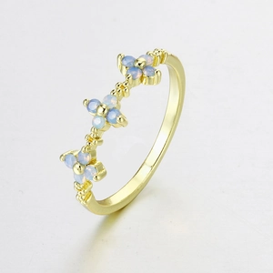 Detailed side view of gold-plated ring with three light blue opal flower-shaped motifs