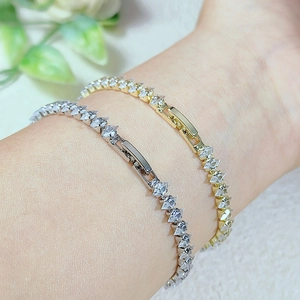 Dettaglio dei bracciali tennis color oro e argento con zirconi micro-incastonati