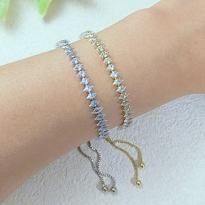 Dettaglio di braccialetti tennis in oro e argento con zirconi a zigzag e chiusura regolabile