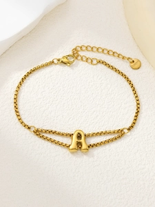Detail van de dubbellaagse vergulde roestvrijstalen schakelarmband met letter A hanger